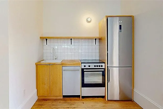 Utility kitchen with butcher block countertops and modern stainless steel appliances.