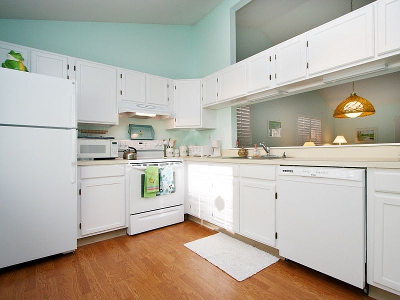 Bright, cheery, up-dated kitchen boasting wood floors and having a big bay win