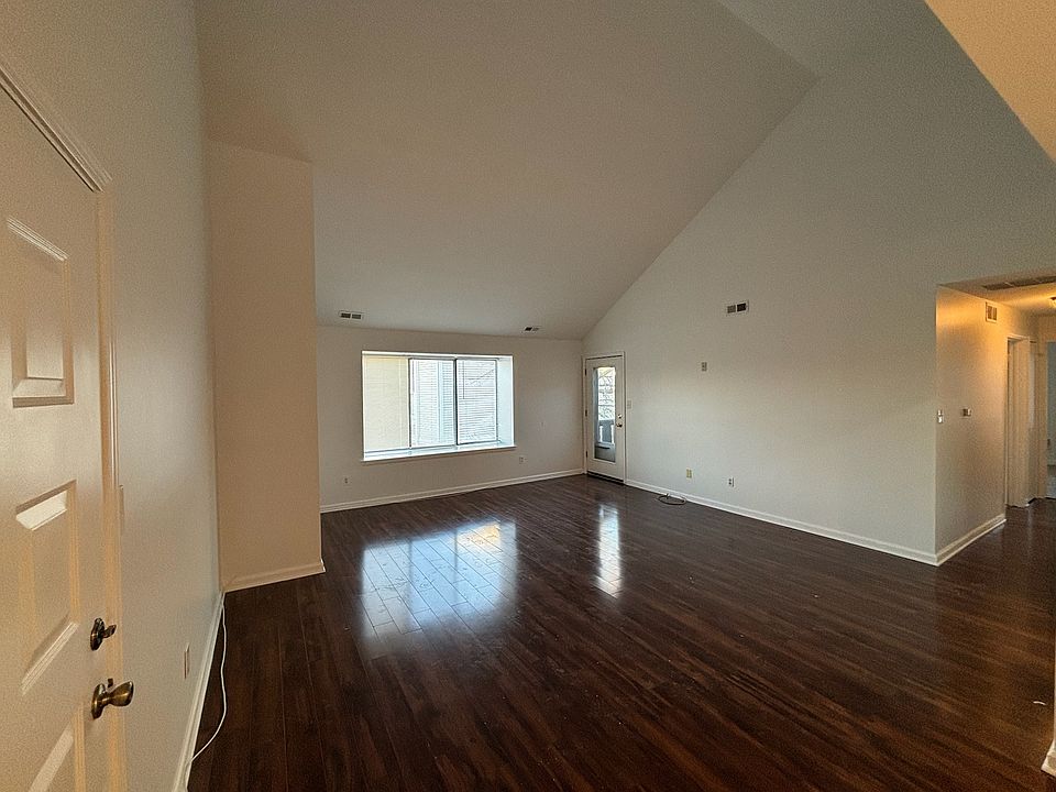 Living room with vaulted ceiling and balcony access.