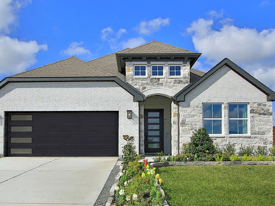 Elegant facade featuring premium brick and stone detailing in River Ranch. Beautifully landscaped en