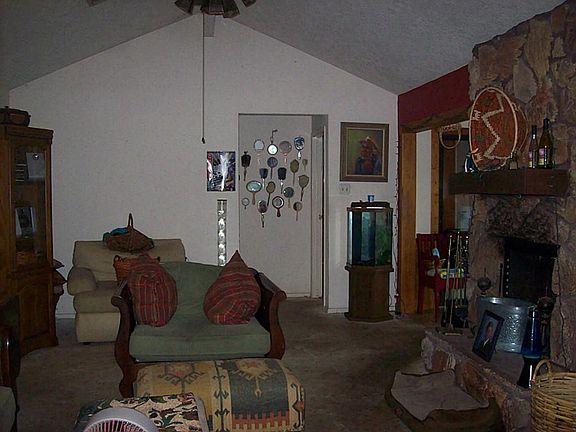 View of spacious living room showing rock/stone fireplace.