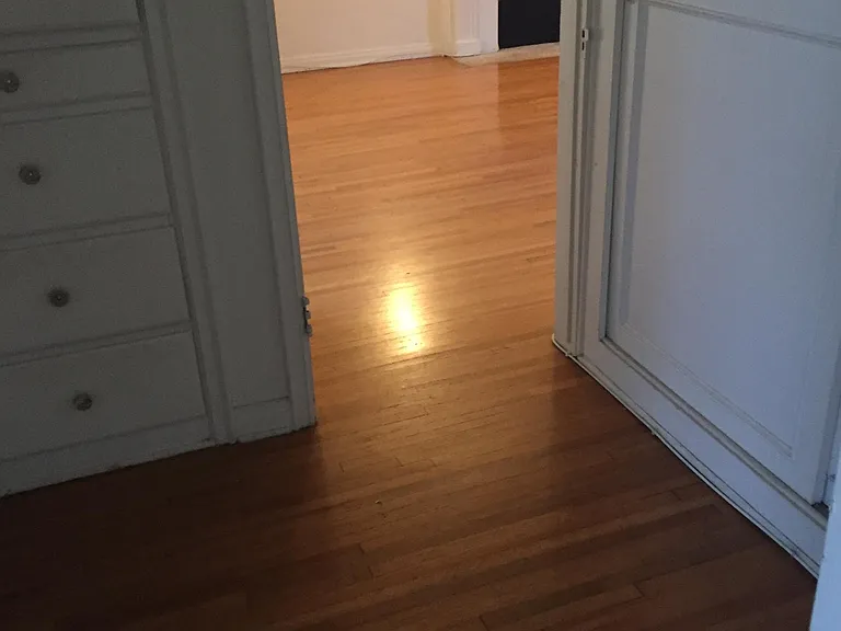 Hallway between living room and bedroom with built-in drawers and full sized closet.