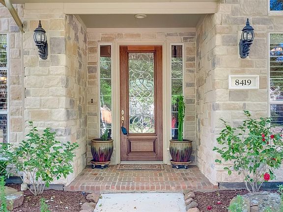 The front porch is both welcoming and pretty boasting rich wood front door with elaborate etched pane.