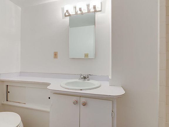Private bathroom with small cabinet for storage. Bathroom features a tiled standing shower.