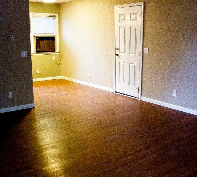 Standing at front door looking into dining room. Window air has been replaced with a mini-split. Door goes to garage