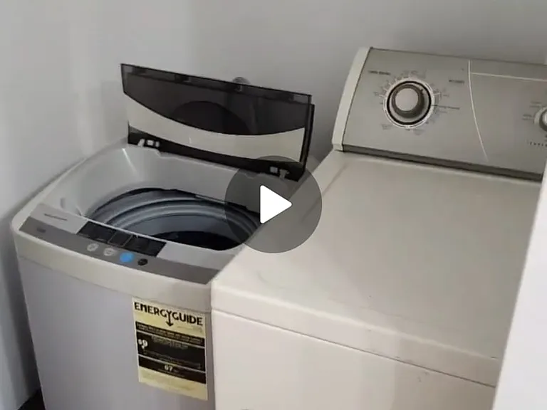 this photo shows the shared washer dryer closet inside the shared full size bathroom featuring a full size dryer and a electronic display automatic washing machine with a one push button start