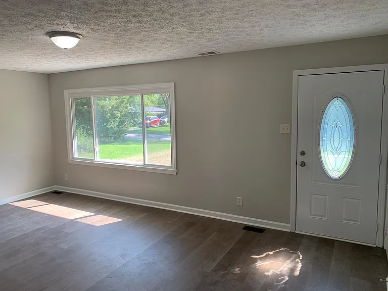 Front door leads to a large living room drenched with sunlight
