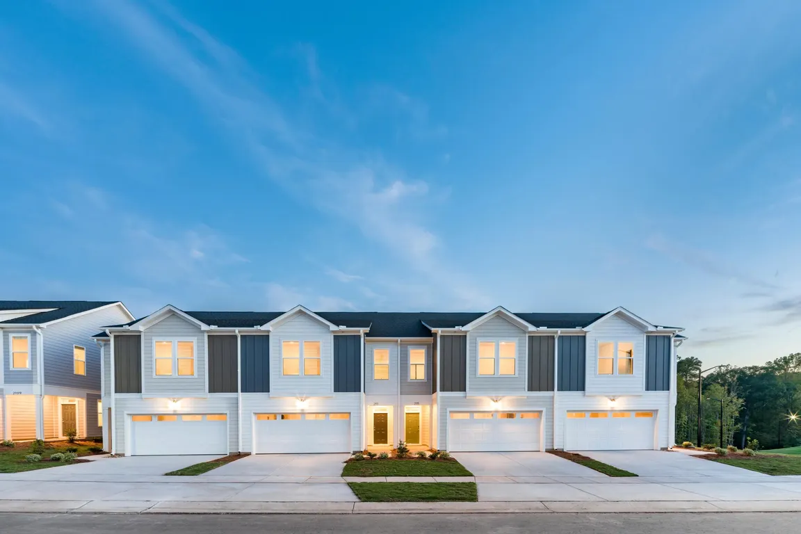 Evening curb appeal at Amavi Brier Creek, featuring modern townhome living in Durham with quick access to Brier Creek shopping, dining, and major roadways.