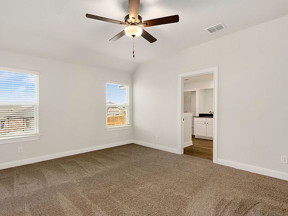 Master bedroom with two large windows and an attached bathroom.