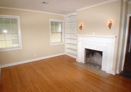 Living room with faux fireplace, built-in bookcase, antique sconces