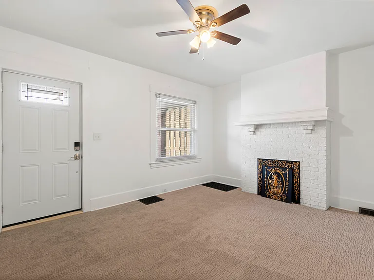 Living Room with neutral decor, decorative fireplace, and ceiling fan/light combo. As well as new front door!