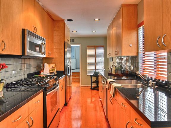 The upgraded kitchen has stainless steel appliances and black granite counters