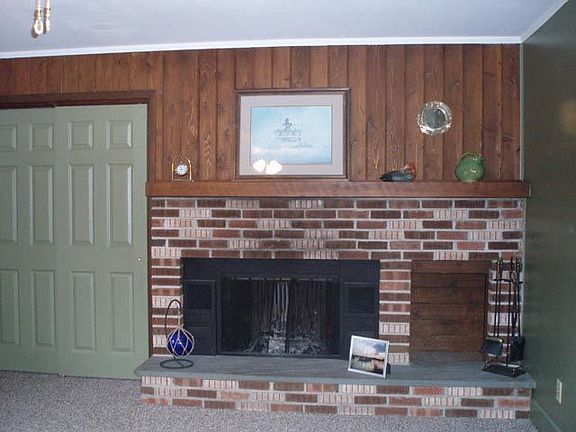 A wood burning FP surrounded with brick accenting and a decorative wood Mantle