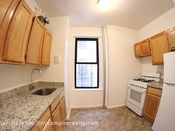 Kitchen with stone counters and new cabinetry. New white appliances as well.
