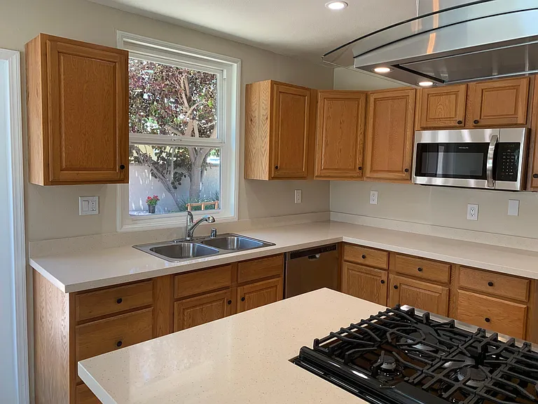 Kitchen with new appliances and quartz countertops.