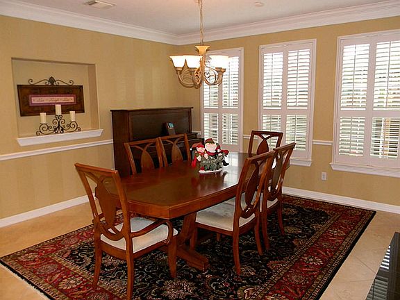Formal dining is spacious enough to host any type of entertaining and features natural lighting, plantation blinds, and wall art niche.