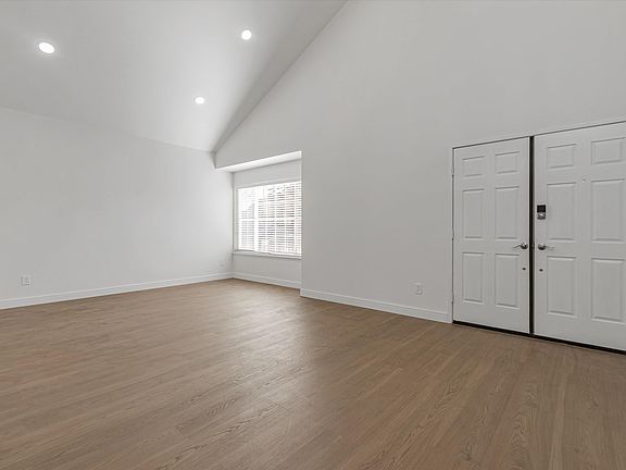 Living room and hallway with high ceilings.