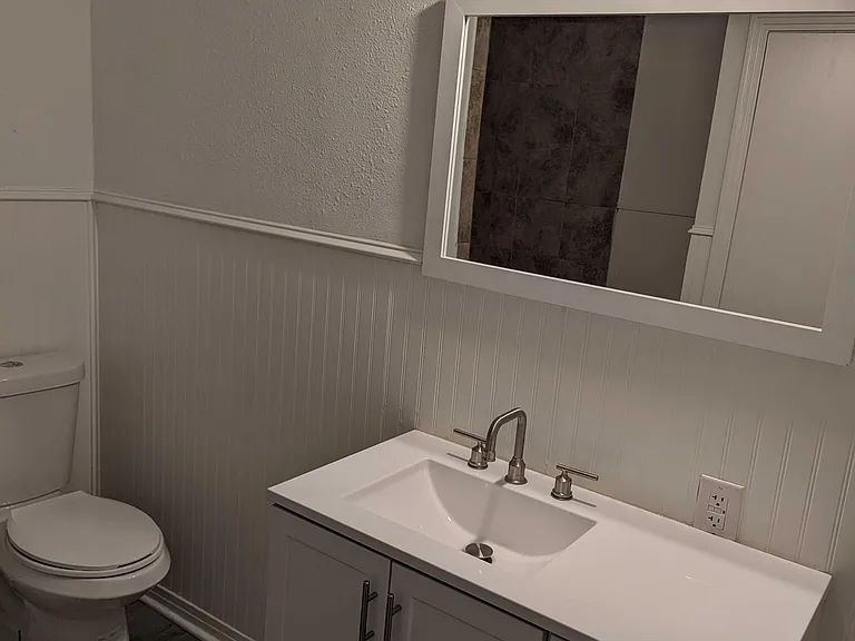 Freshly remodeled bathroom - new floors, vanity and light fixture.