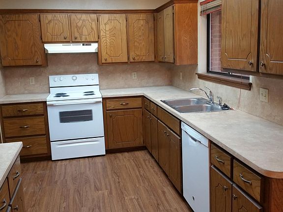 Kitchen with lots of cabinetry and counter tops. Over sink window looks out onto the back patio area and yard.