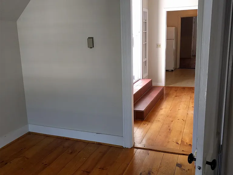 view from front room to living room, showing steps to roof deck sliding glass doors