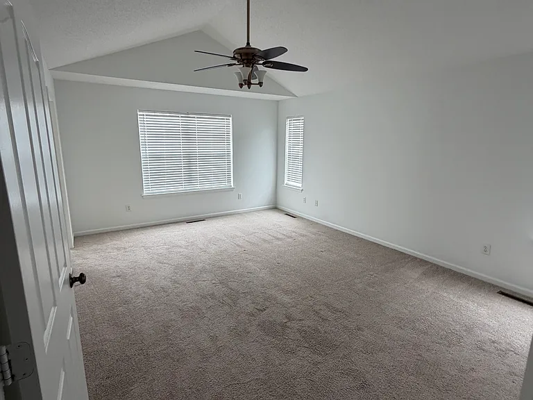 Primary Bedroom with cathedral ceiling, 2 walk in closets, and a PrimaryBath
