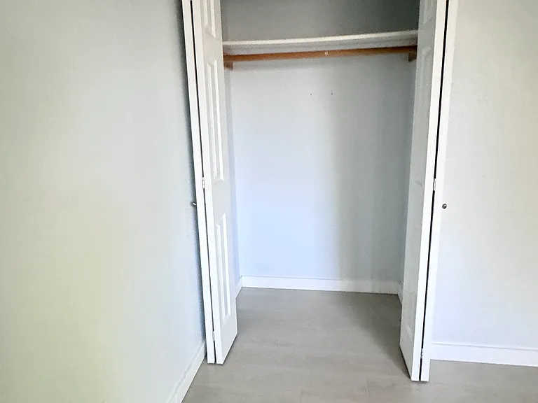Guest bedroom with closet and window view of patio