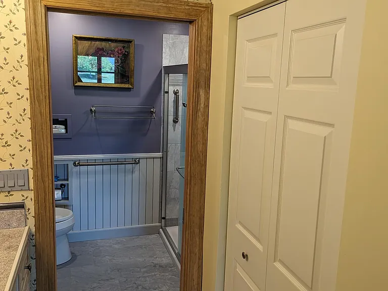 master wide closet with by-pass doors across from vanity. Porcelain floor tile throughout ensuite