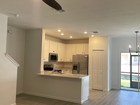 Common area with remote controlled ceiling fan and tiled flooring.