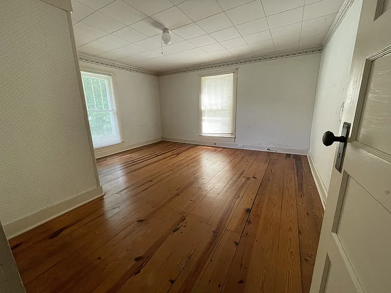 Bedroom #2, knotty pine floors and a view of the farm through both windows.