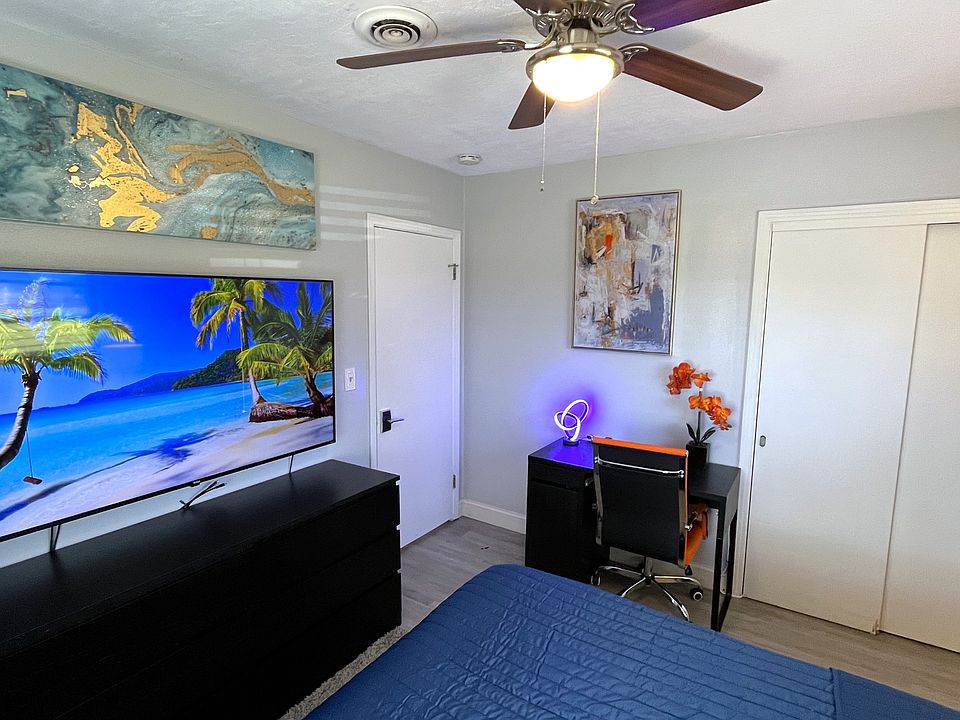 Room 2 features: Queen bed, dual night stands, table lamps, ceiling fan, mini fridge, desk, 65in TV