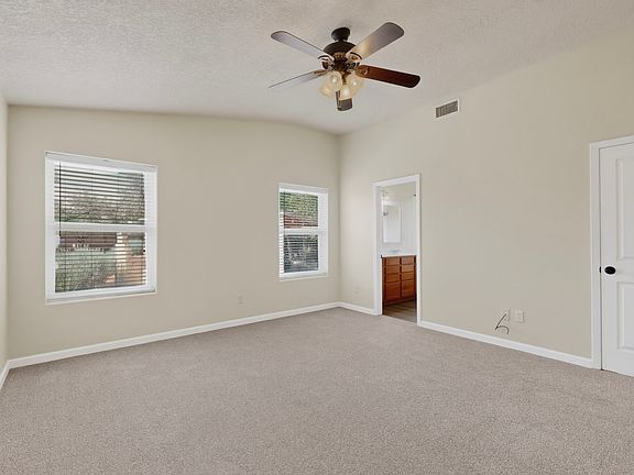 Massive primary bedroom with private primary bathroom and walk in closet and high vaulted ceilings.