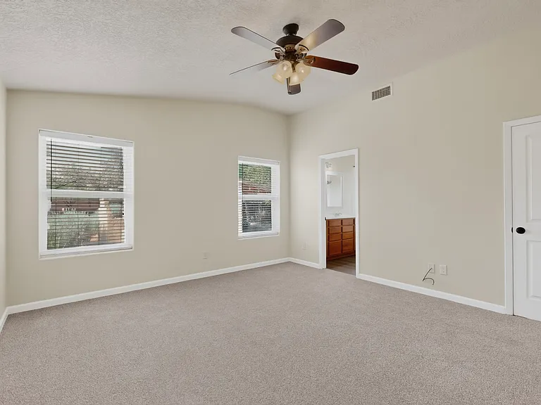 Massive primary bedroom with private primary bathroom and walk in closet and high vaulted ceilings.