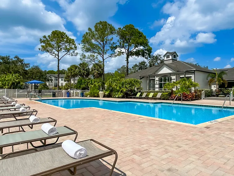 Loungers, umbrellas, and a lakeside backdrop create the ultimate pool experience in sunny Bradenton!