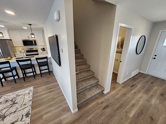 Stairs leading to upstairs living spaces. (Pictures are of another unit with similar finishes and features.)