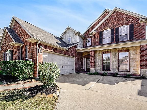 This beauty has stone and brick exterior with extra-wide driveway, side entry garage, and lush landscaping adorns the front porch.