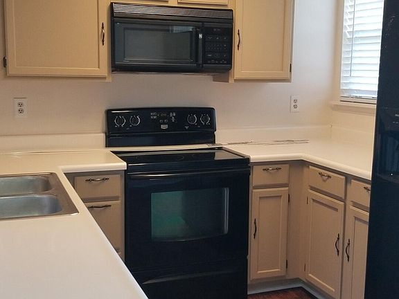 Kitchen with black appliances - LVP flooring new window treatments and paint.