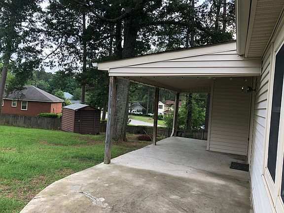 Large back yard with storage building and outside storage