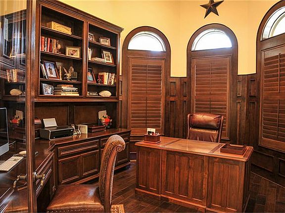 This generously-sized study has room for two work areas. The rich wood built-ins, wood floors, and w