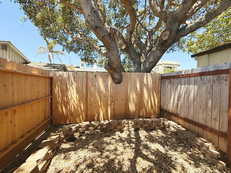 patio has rock pebble flooring. Garden bed is currently empty but can be filled with beautiful shade-friendly greenery!