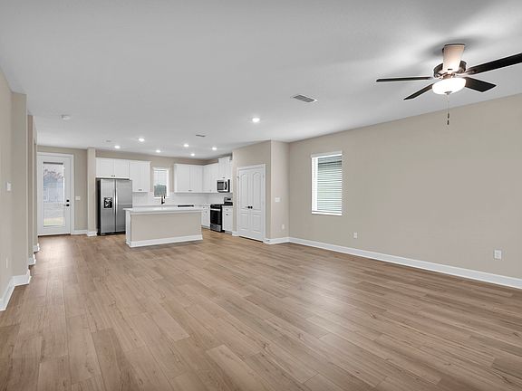 The spacious kitchen island serves as a perfect use for meal preparation or casual seating.