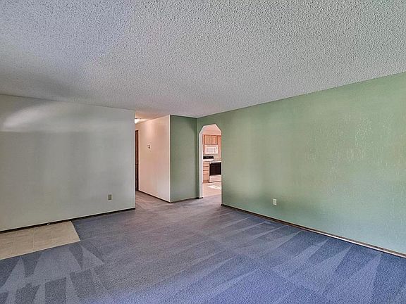 New carpet is neutral color and wall color is off-white.