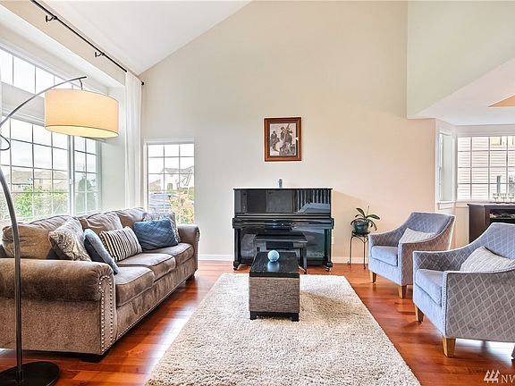 Spacious living room with vaulted ceilings, hardwood floors & big picture windows for lots of natural light.