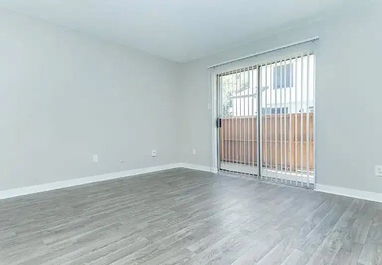 Explore the spacious interiors of Cali Crossing Apartments, where modern comfort meets style. Enjoy the serene sliding door that opens to your outside space and the sleek flooring that enhances your living experience. Schedule a tour today!