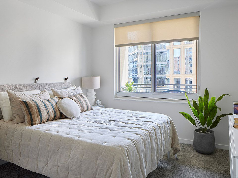 Spacious apartment bedroom with polished concrete flooring.