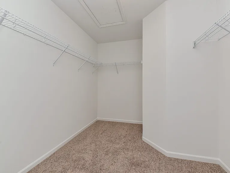 Primary bedroom with attached en suite bathroom and walk in closet