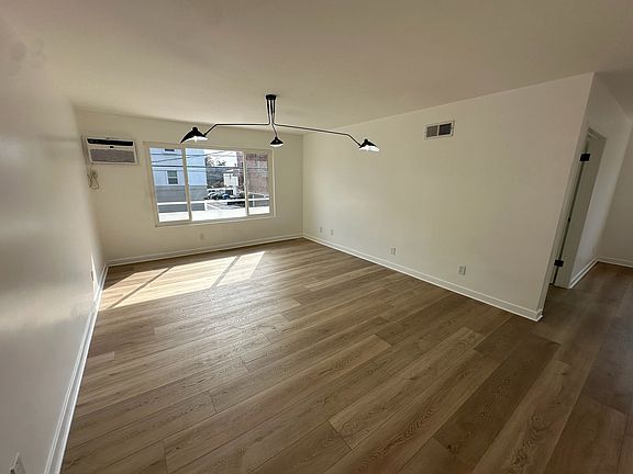 Living Room: Fully Renovated: New Floors, AC, Light fixture, tons of light.