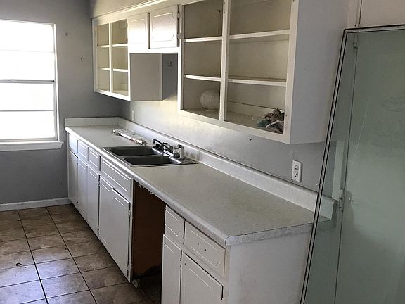 Kitchen is a galley shape, with more cabinets on the left with room for a refrigerator and stove. The empty space just under the sink will have a dishwasher installed.