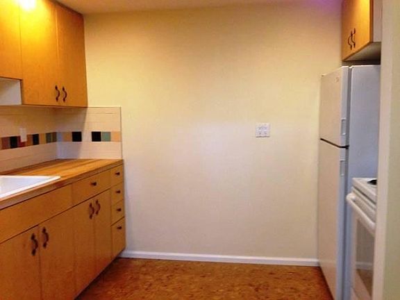 Kitchen with newer cork floors, wood cabinets & appliances