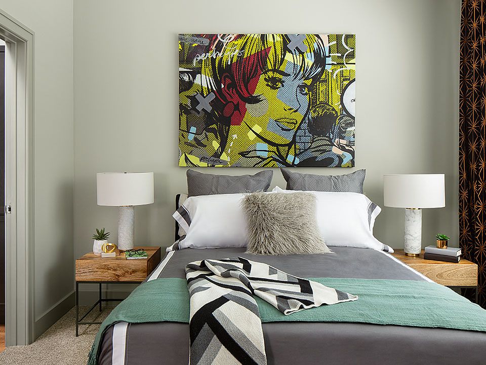 Spacious apartment bedroom with wood floors overlooking bathroom.