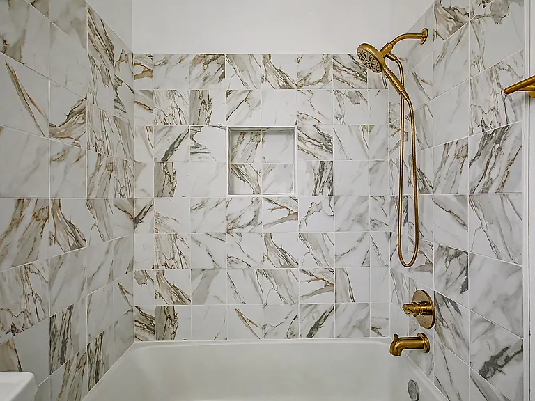 Hallway bathroom with newly renovated tub/ shower.